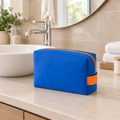 Bolsa azul y naranja en un baño con lavabo y espejo