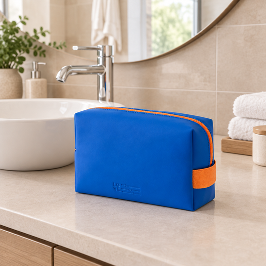 Bolsa azul y naranja en un baño con lavabo y espejo